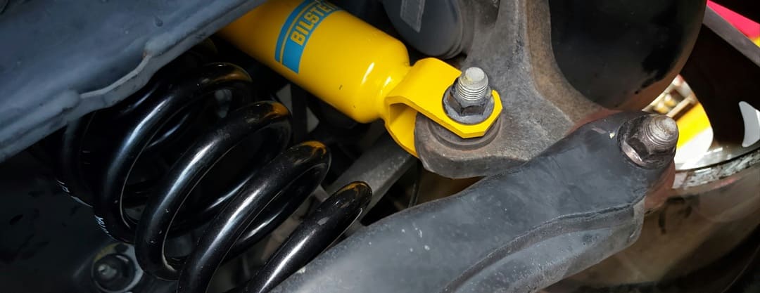 Amortecedor Bilstein montado no veículo, com a mola helicoidal e o braço de suspensão visíveis
