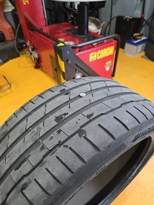 Técnico a inspecionar um pneu furado